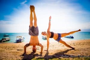 the traveling blondie doing yoga poses on the beach